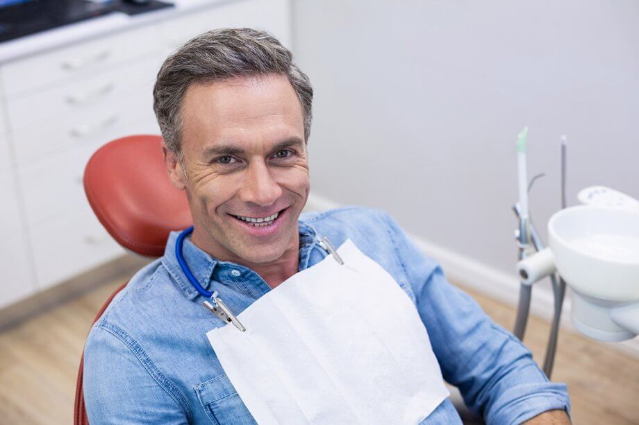 Middle-aged man smiling in dental exam chair