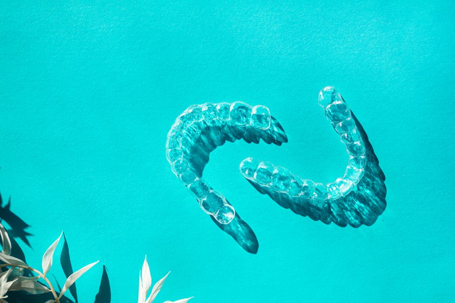 clear dental aligners on turquoise blue background