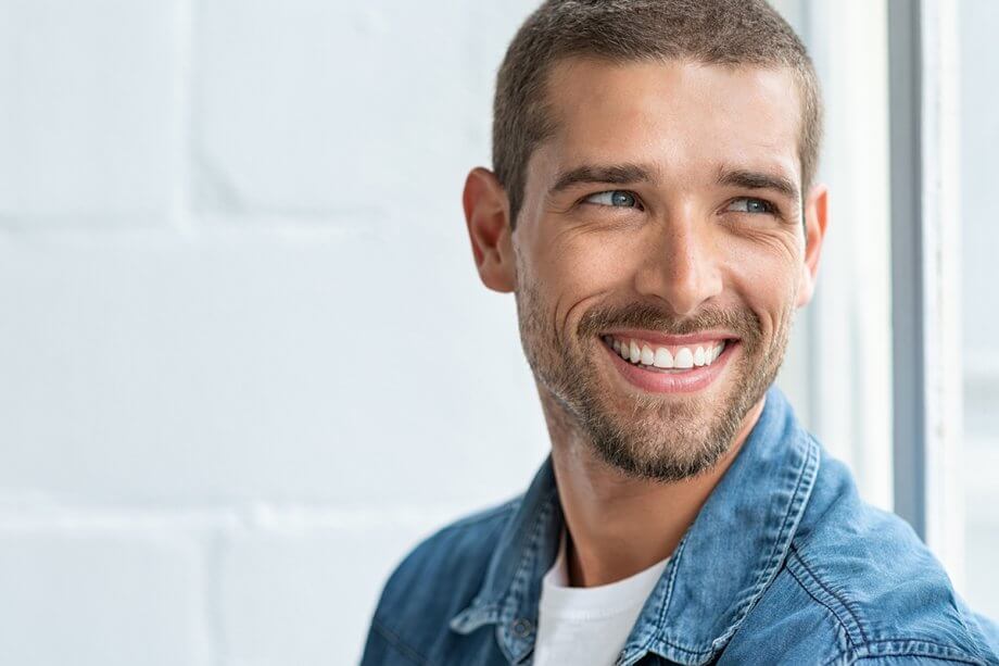 young man smiling looking off to the side