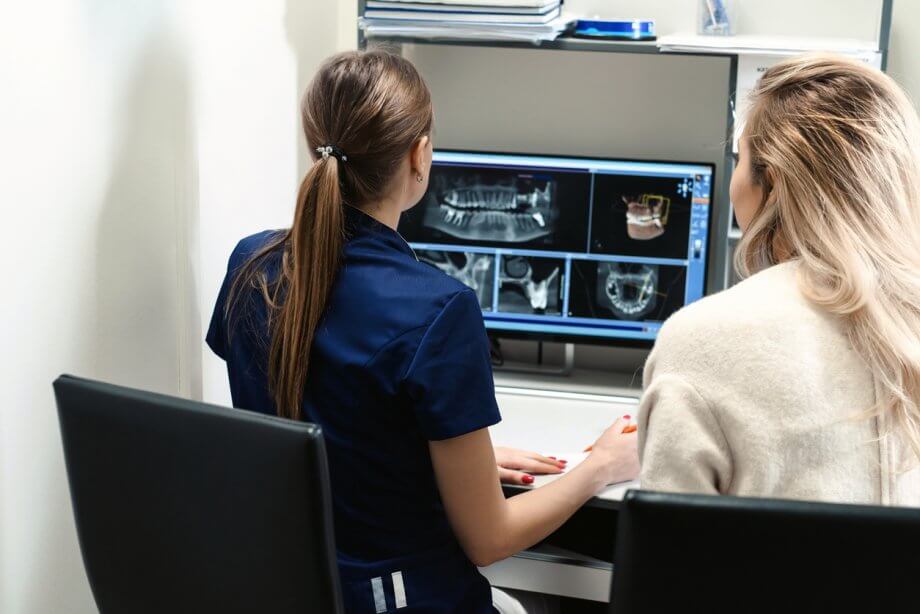 Female Dentist Shows X-Rays of New Crown