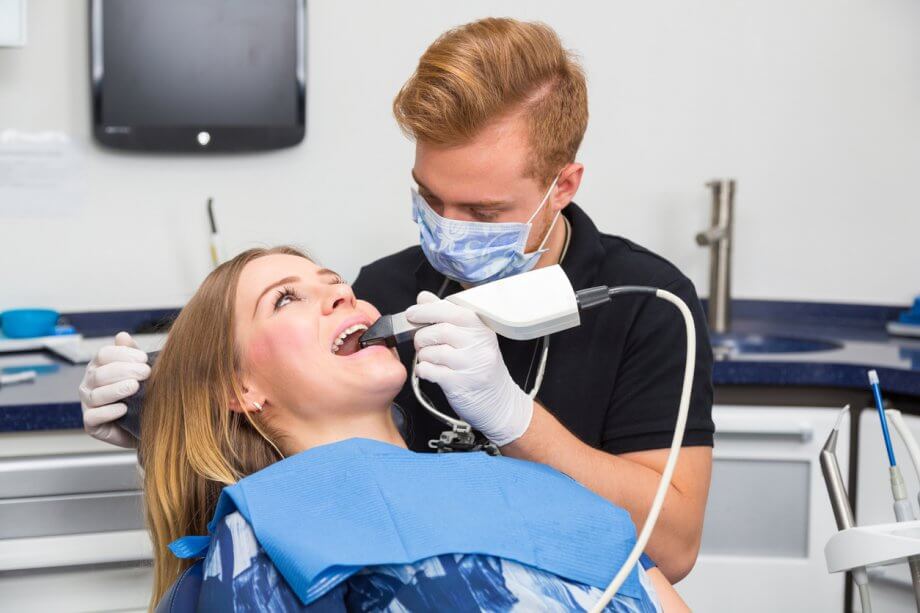 Dentist Scanning the Teeth of Patient with CEREC Scanner