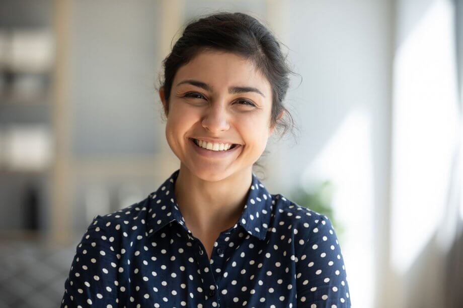 young smiling woman wearing navy shirt with white polka dots